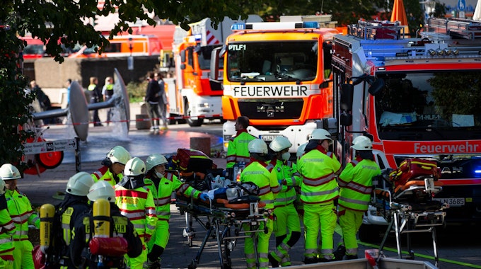 Rettungskräfte stehen am Samstag (8. Oktober 2022) während der Löscharbeiten am U-Bahnhof Ebertplatz in Köln.