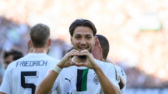 Ramy Bensebaini von Borussia Mönchengladbach erzielte im Derby gegen den 1. FC Köln am Sonntag (9. Oktober 2022) zwei Tore. Das Foto zeigt ihm beim Jubel nach dem 4:1. Mit den Händen formt er ein Herz.