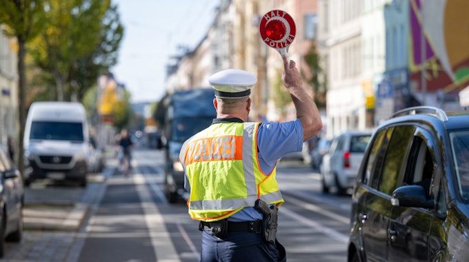 Leipzig: Ein Verkehrspolizist winkt einen Transporter in eine Polizeikontrolle.