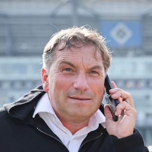 Thomas Wüstefeld telefoniert vor dem Spiel auf dem Parkplatz vor dem Stadion.
