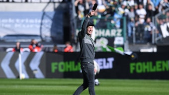 Stadionsprecher Torsten „Knippi“ Knippertz am 9. Oktober 2022 vor dem Bundesliga-Heimspiel von Borussia Mönchengladbach gegen den 1. FC Köln. Knippertz steht auf dem Rasen im Borussia-Park, in der rechten Hand hält er ein Mikrofon.