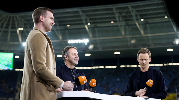 Deutschlands Trainer Hans-Dieter Flick (M.) im Interview mit dem ehemaligen Nationalspieler Per Mertesacker (l.) und TV-Moderator Jochen Breyer vom ZDF.