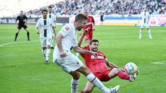Christoph Kramer von Borussia Mönchengladbach schlägt eine Flanke im Derby gegen den 1. FC Köln am 9. Oktober 2022, Gegenspieler Jonas Hector will das verhindern.