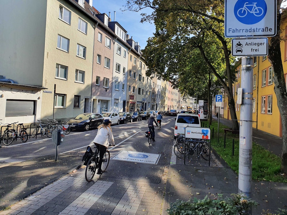 Radfahrerinnen und Radfahrer fahren über die neue Fahrradstraße an der Griechenpforte im Kölner Zentrum.