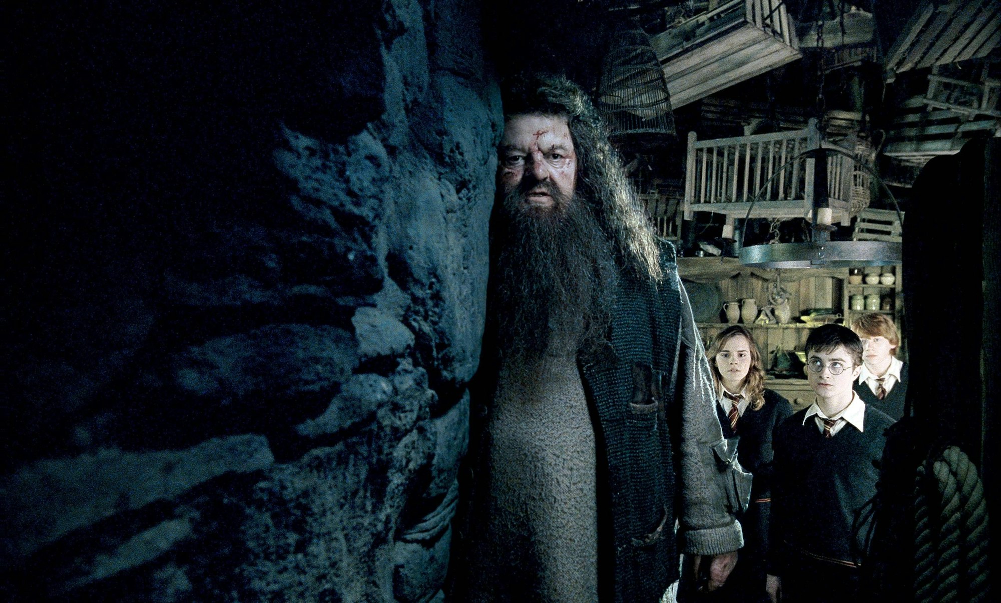 Robbie Coltrane als bärtiger Hagrid in einer Szene der „Harry Potter“-Filme. Rechts neben ihm Schauspielerin Emma Watson (als Hermione) sowie ihre Kollegen Daniel Radcliffe (als Harry) und Rupert Grint (als Ron, rechts).