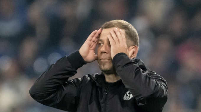 Trainer Frank Kramer von Schalke verfolgt das Spiel und schlägt die Hände vors Gesicht.