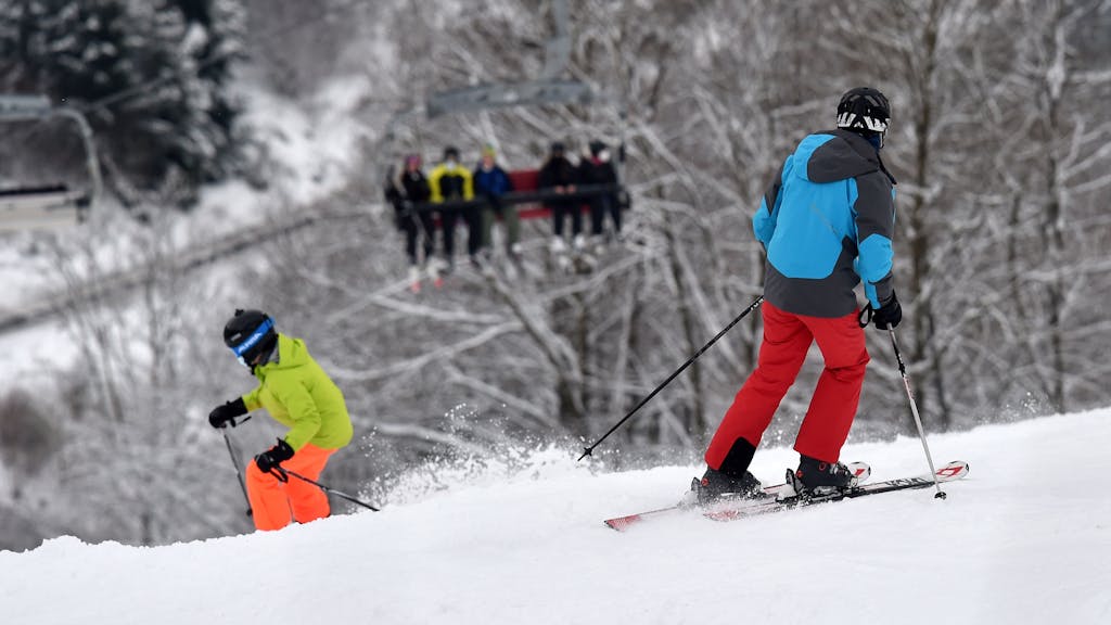 Wintersportler fahren mit Skiern einen Hang in Winterberg runter. Archivfoto aus dem Winter 2021/2022.