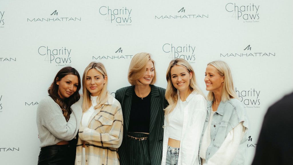 Model Vanessa Tamkan steht mit vier Bloggerinnen vor einer Wand mit der Aufschrift "Charity 4 Paws".