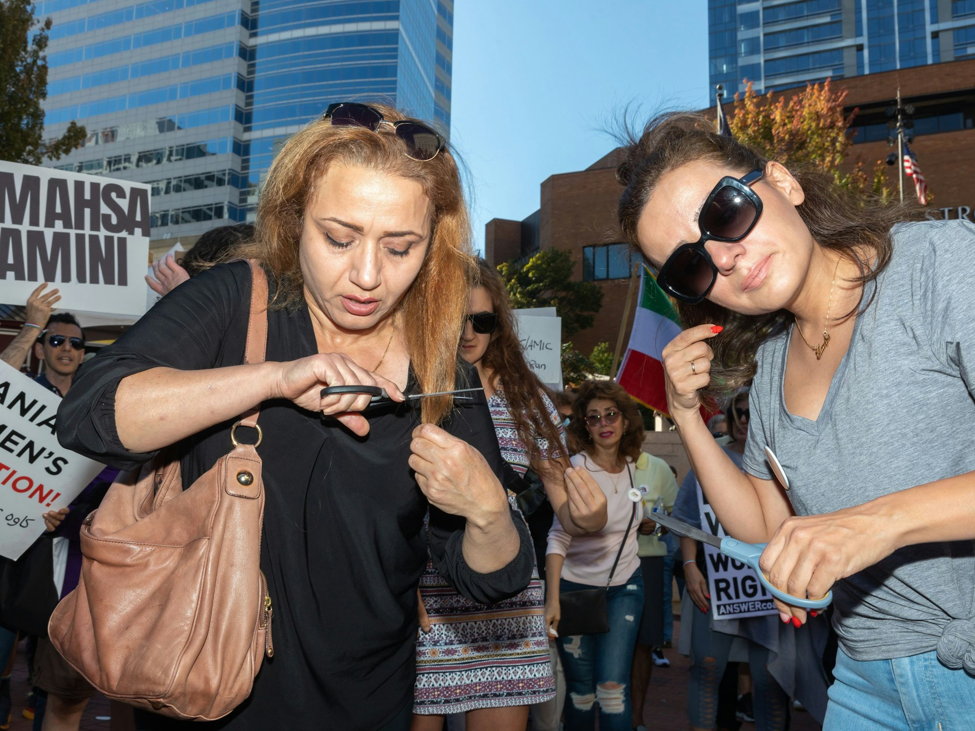 Zwei Frauen schneiden sich als Zeichen der Solidarität Haare ab.