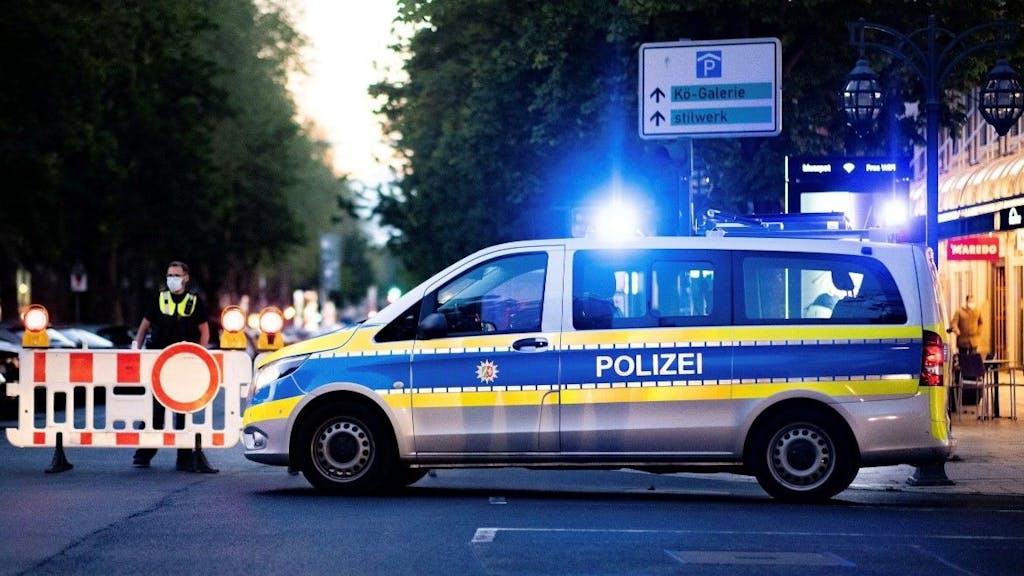 Ein Polizist errichtet Absperrungen auf der Königsallee in Düsseldorf.
