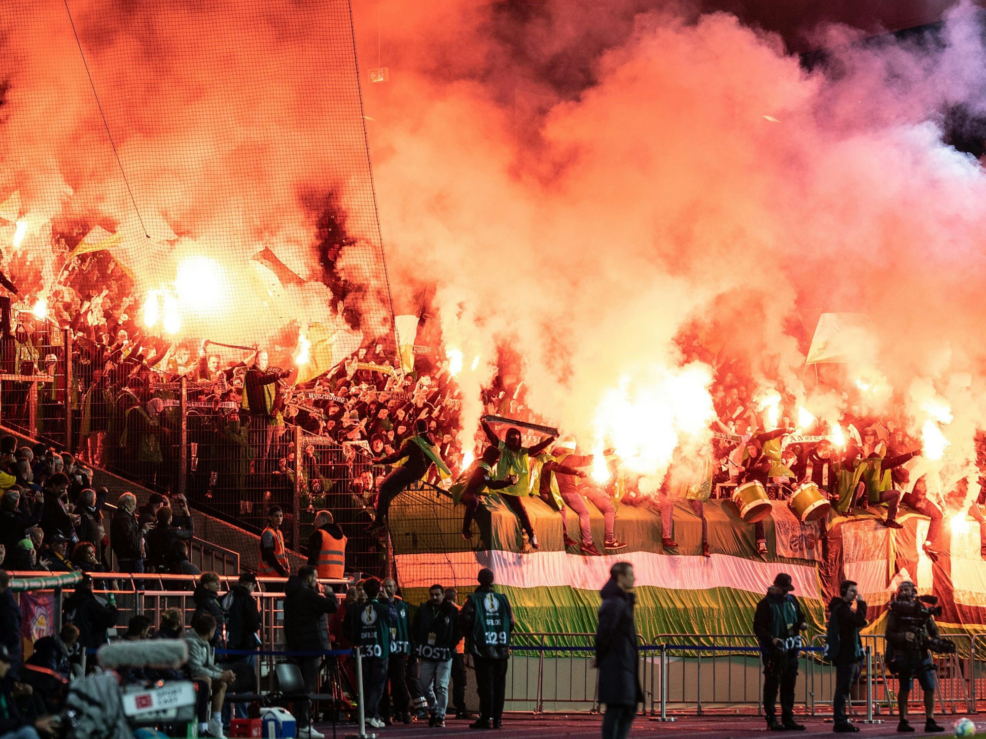 Eintracht-Stadion:Die Fans des VfL Wolfsburg stehen im Pyro-Nebel.