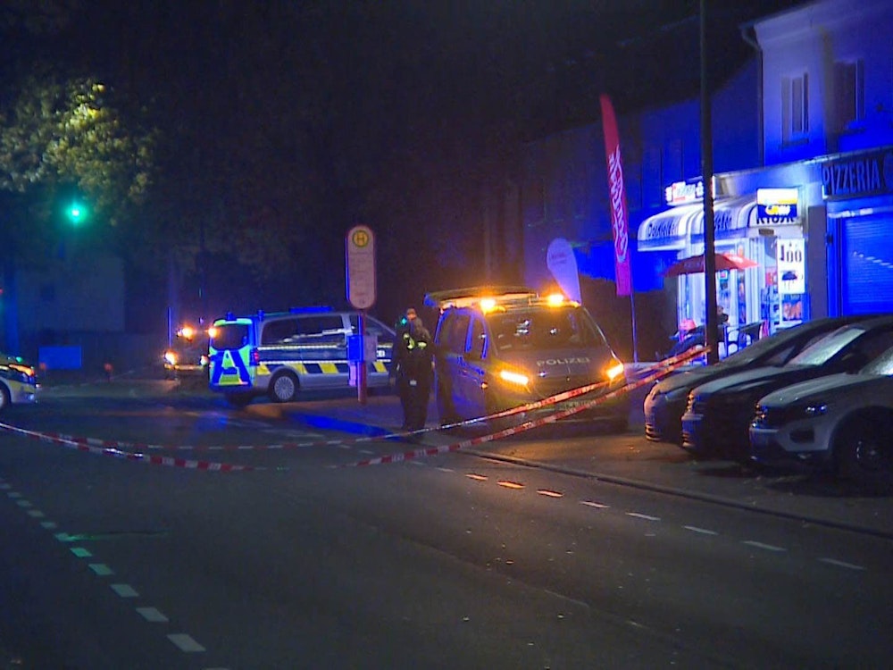Einsatzkräfte der Polizei haben eine Straße in Dortmund abgesperrt. Die Lichter der Autos sind an, weil es noch dunkel ist.