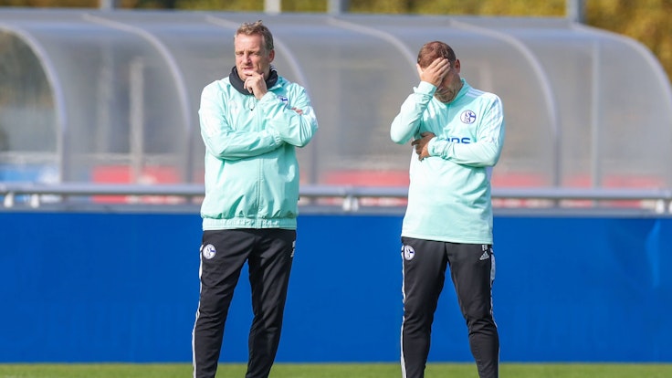 Co-Trainer Mike Büskens und Frank Kramer stehen auf dem Platz beim FC Schalke 04.