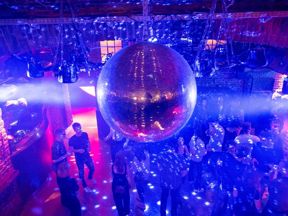 Hier feiern nur wenige Leute nach Corona, bei Disco-Beleuchtung im Kölner Club Roonburg.