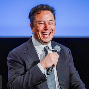 Elon Musk hält ein Mikro in der Hand.