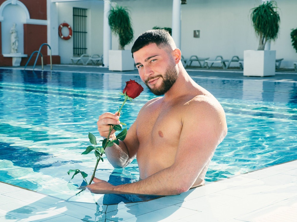 Umut posiert im Pool mit einer Rose vor der Kamera.