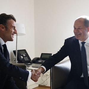 Emmanuel Macron (l.) und Olaf Scholz schütteln sich am 20. Oktober 2022 lächelnd die Hände. Doch zwischen den beiden Regierungschefs knirscht es.