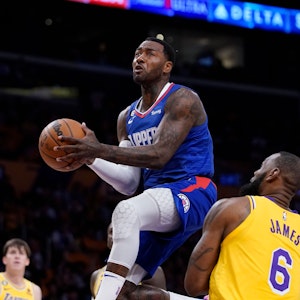 Clippers-Profi John Wall (l.) steigt hoch zum Korb, Lakers-Star Lebron James kann nur zugucken.