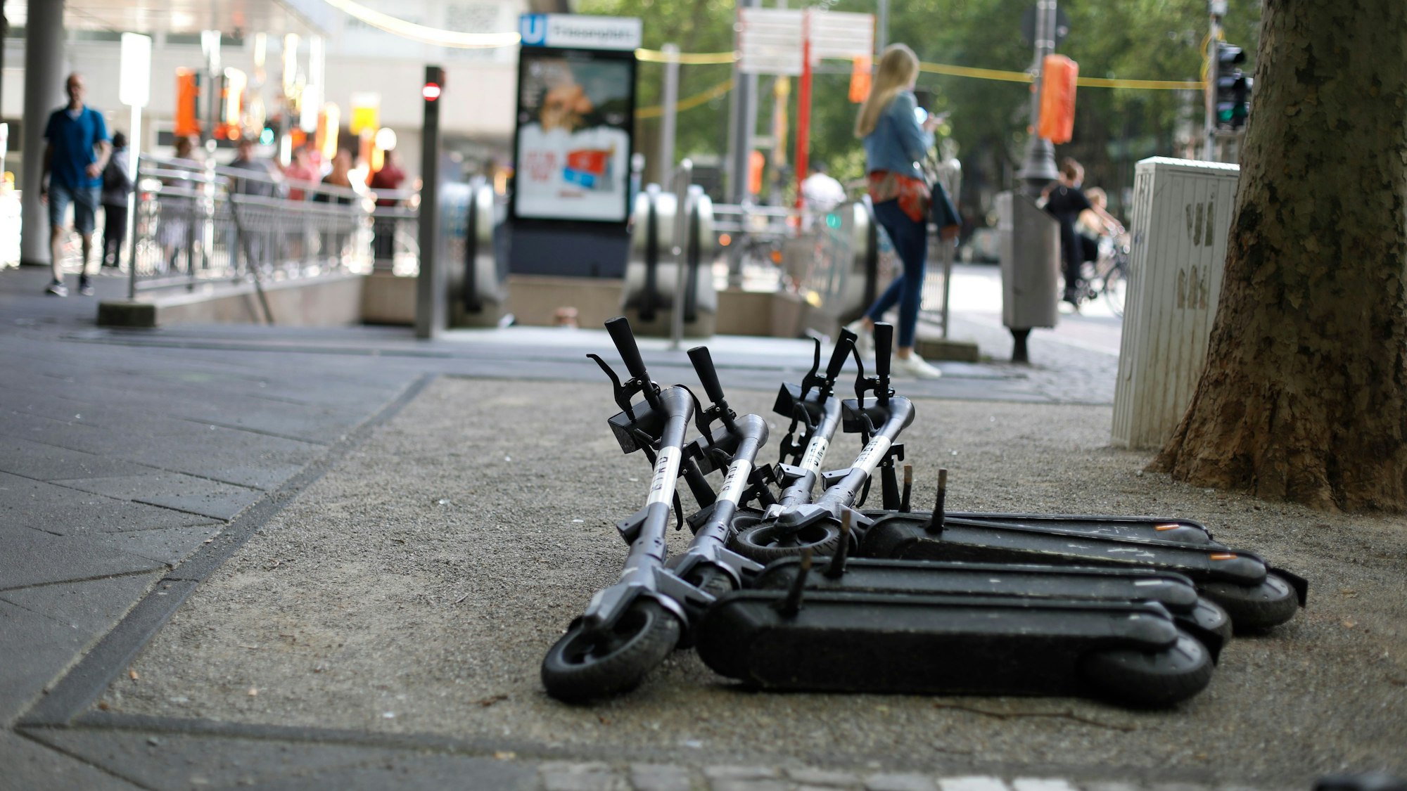 Abgestellte E-Scooter des Anbieters Bird liegen umgekippt neben dem Gehweg in Köln.
