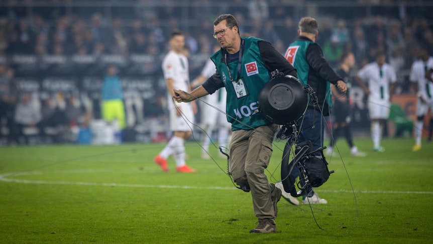 Ein Techniker trägt die defekte Spidercam vom Spielfeld, geschehen beim Bundesliga-Spiel Borussia Mönchengladbach gegen Eintracht Frankfurt im Borussia-Park am 22. Oktober 2022.