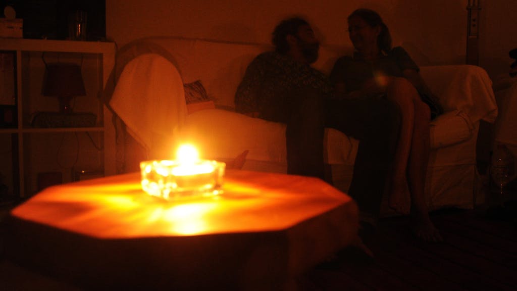 Ein Paar sitzt während eines Stromausfalls bei Kerzenschein in einer Wohnung in Hannover. In Bayern laufen derzeit die Planungen für einen großflächigen und langanhaltenden Stromausfall, einen sogenannten Blackout.&nbsp;