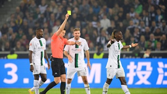 Schiedsrichter Daniel Siebert zeigt Manu Koné (r.) von Borussia Mönchengladbach die Gelbe Karte im Bundesliga-Topspiel (22. Oktober 2022) gegen Eintracht Frankfurt. Koné ist damit nicht einverstanden und gestikuliert.