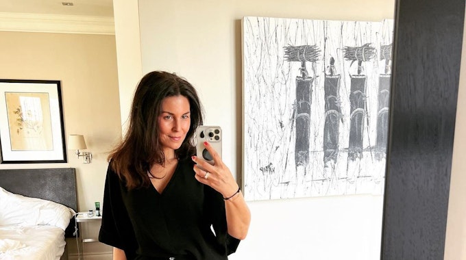 Vanessa posiert vor einem Hotelzimmer-Spiegel für ein Selfie.