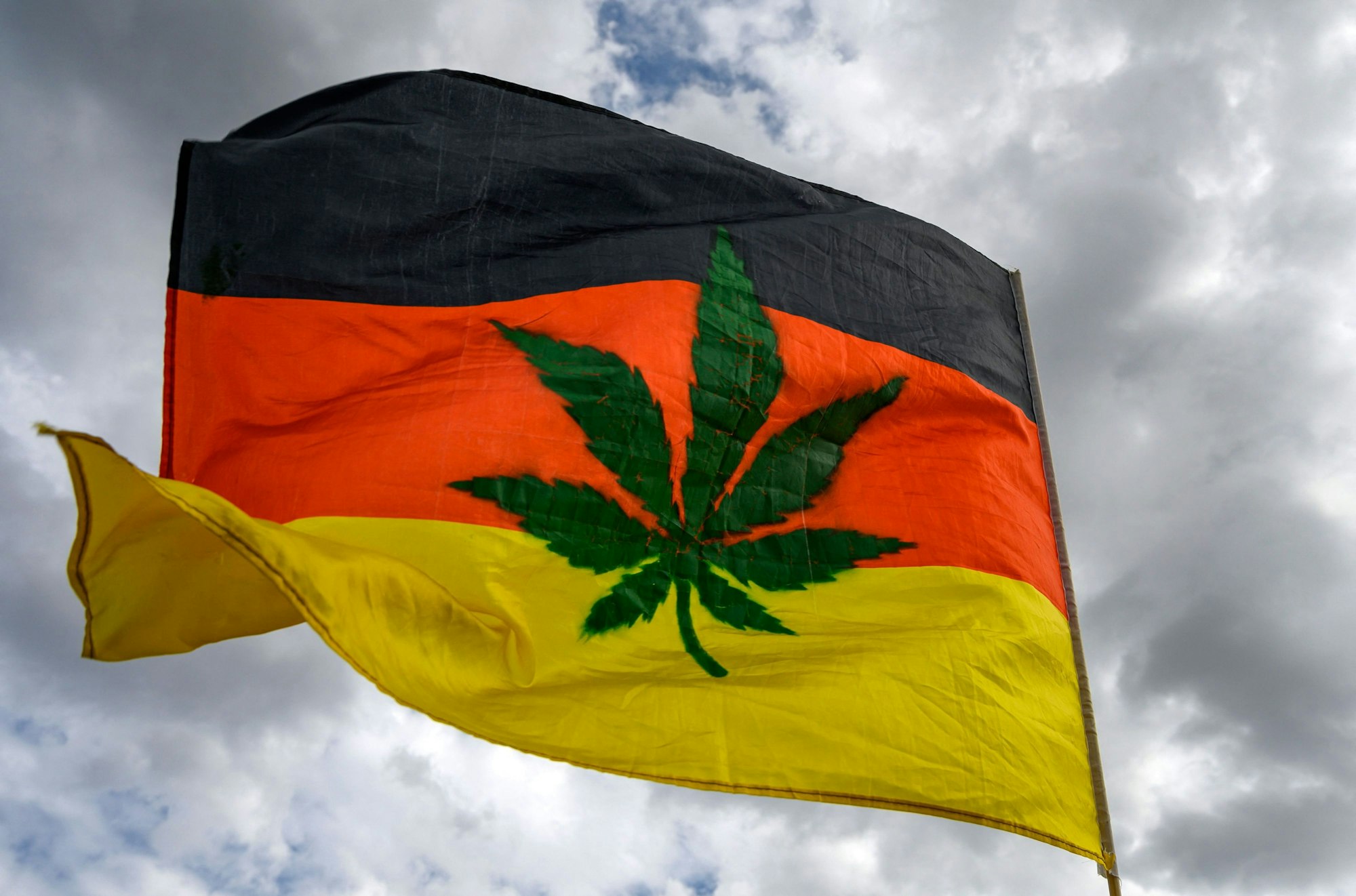 Eine mit einer Marihuana-Pflanze verzierte Deutschland-Flagge.
