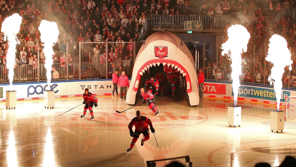 Die Spieler der Kölner Haie betreten das Eis durch eine Feuershow.