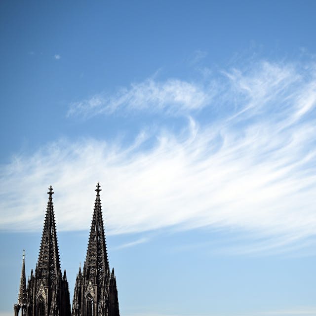 24.08.2022, Nordrhein-Westfalen, Köln: Ein Wolke zieht hinter den Türmen des Doms vorbei. In Nordrhein-Westfalen ist in den kommenden Tagen viel Sonne angesagt. Die Temperaturen werden mit 30 bis 34 Grad erwartet. Foto: Federico Gambarini/dpa +++ dpa-Bildfunk +++