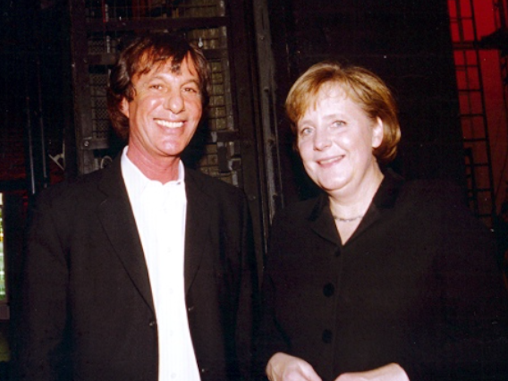 Angela Merkel und Moshe Fleisher schauen in die Kamera.