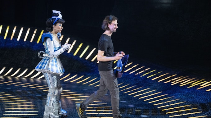 Mann in ziviler Kleidung wird auf der Bühne von Starlight Express geehrt. Das Musical hat 18 Millionen Zuschauerinnen und Zuschauer erreicht.