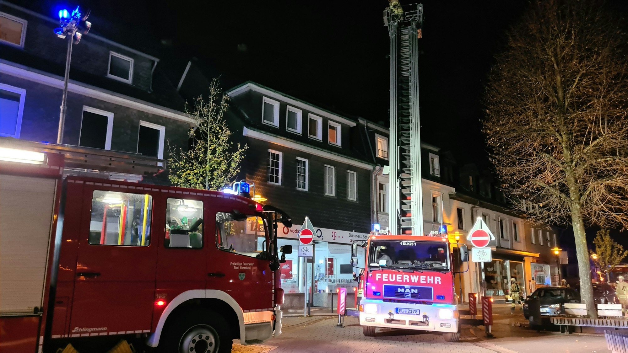 Einsatzfahrzeuge der Feuerwehr Burscheid bei einem nächtlichen Brand in der Innenstadt.