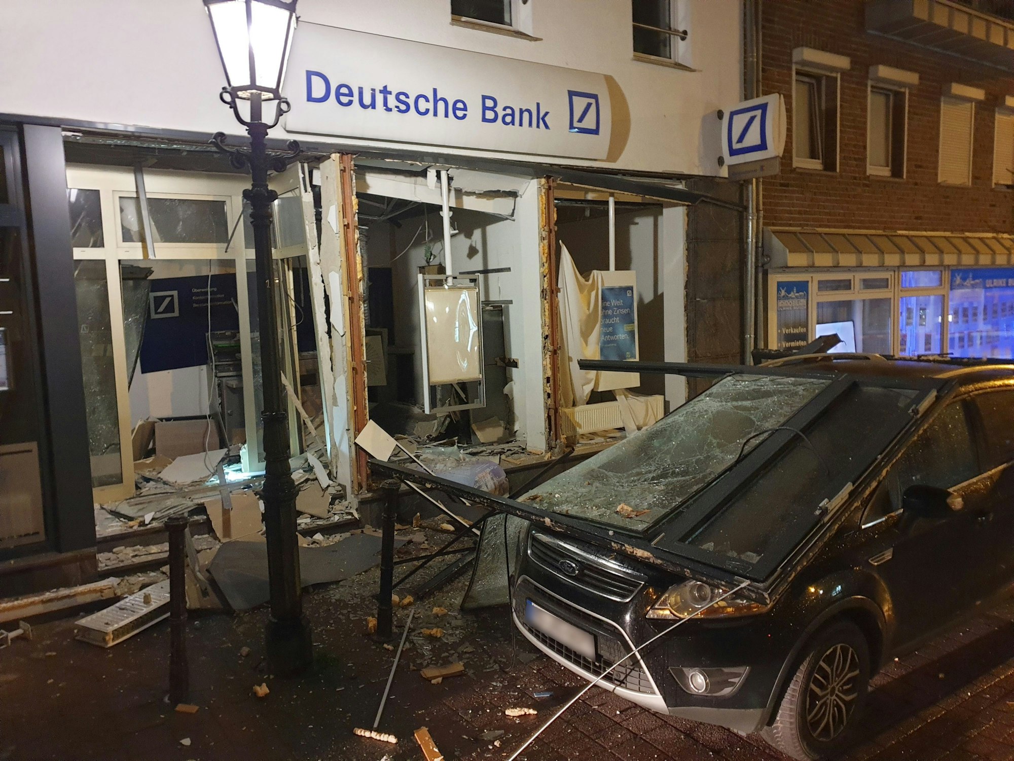 Kaputter Geldautomat und ein beschädigtes Auto nach einer Sprengung in Mönchengladbach.