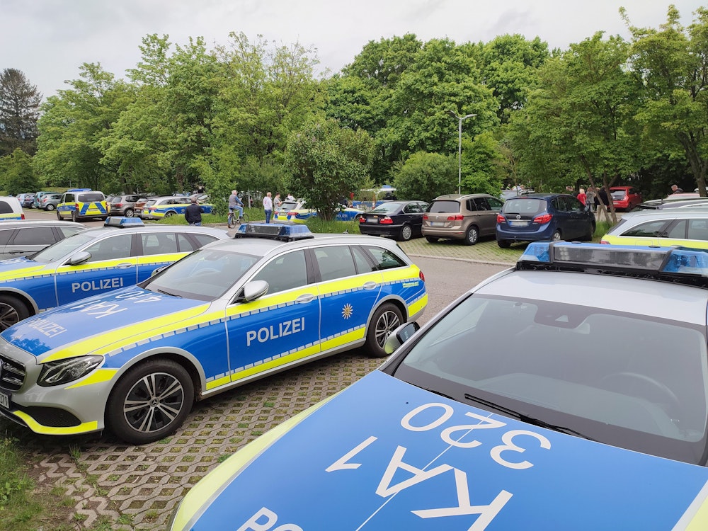 Polizeifahrzeuge stehen auf einem Parkplatz nahe einer Schule.