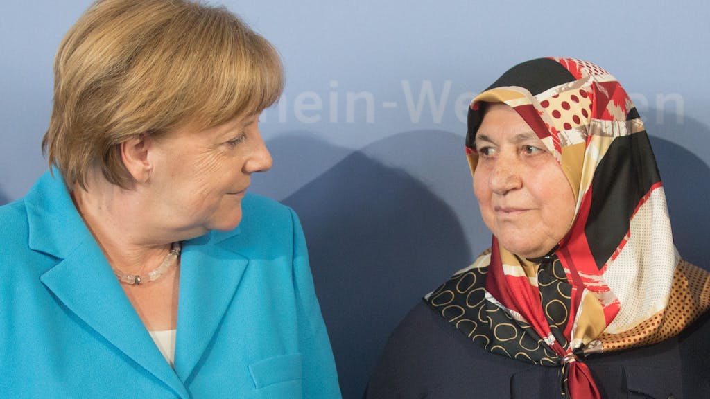 Bundeskanzlerin Angela Merkel (CDU, l) steht neben Mevlüde Genc.