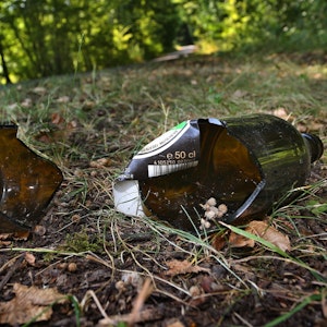 Eine zerbrochene Bierflasche liegt auf dem Boden.
