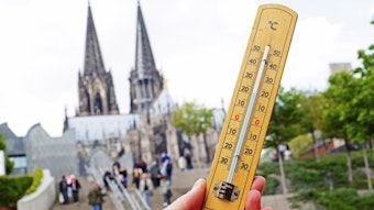Ein Thermometer, aufgenommen in der Altstadt in Köln vor der Treppe am Weltjugendtagsweg, mit dem Kölner Dom im Hintergrund.