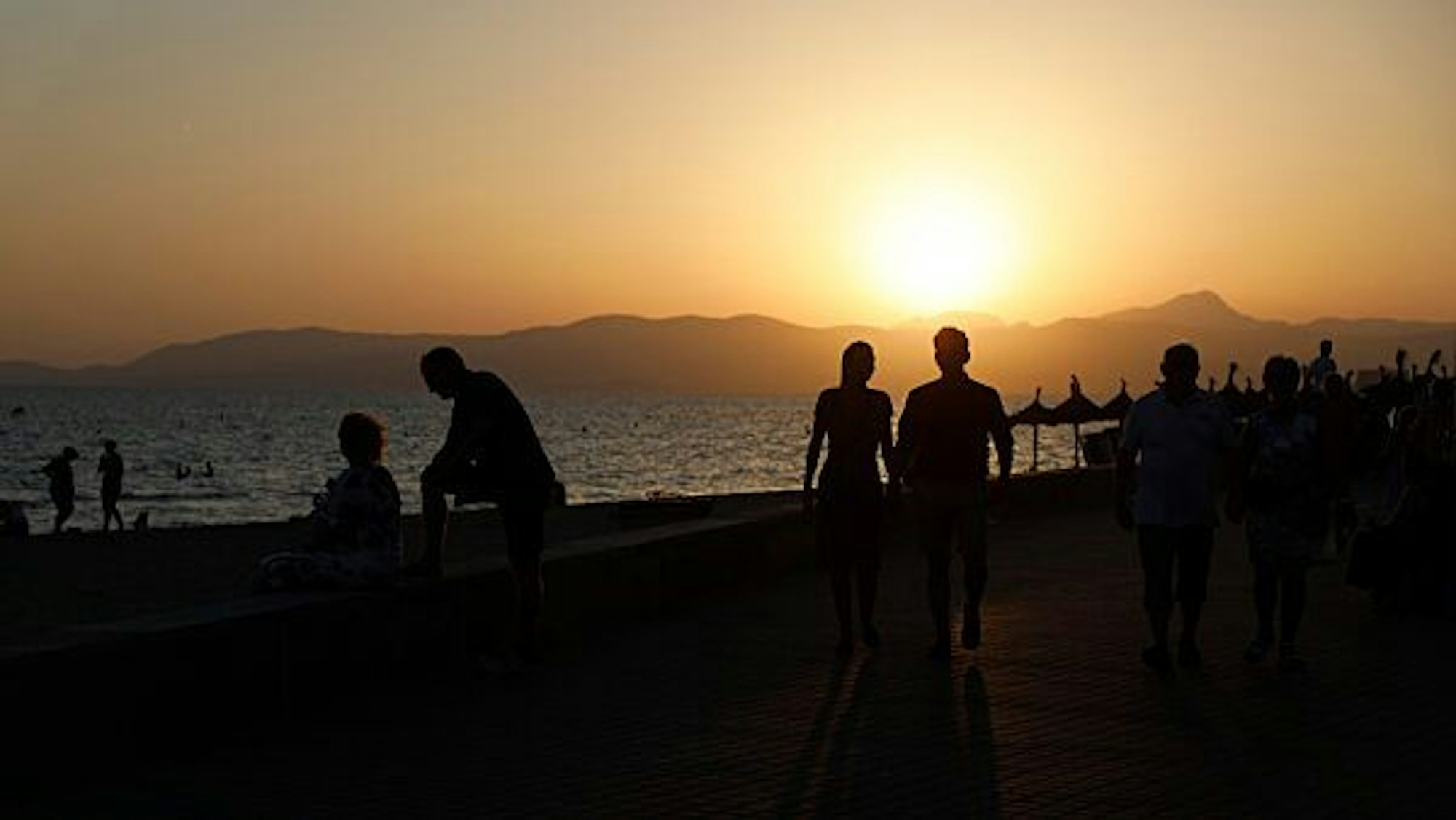Touristen halten sich am Strand von Arenal auf der Ferieninsel Mallorca auf.