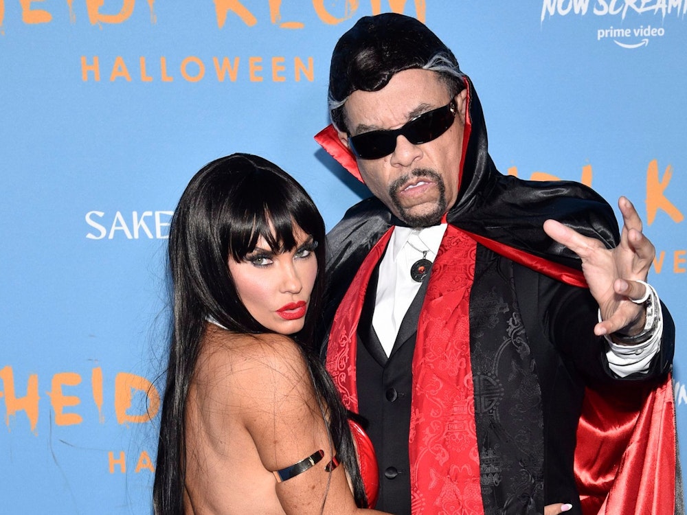 Ice-T trägt eine schwarze Sonnenbrille und einen Vampirumhang. Coco Austin schmiegt sich an ihren Mann und blickt lasziv in die Kamera.