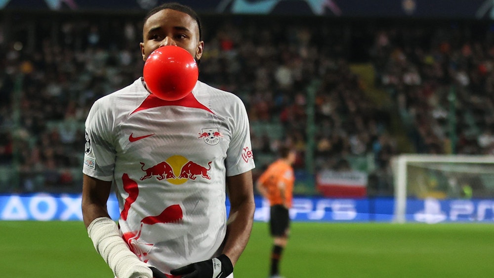 Christopher Nkunku jubelt beim Sieg von RB Leipzig in der Champions League mit Luftballon zwischen den Zähnen.