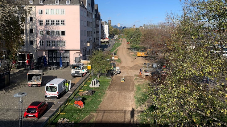 Für die Fahrrad-Umleitung am Pegel in der Kölner Altstadt wird Rasen an der Rheinpromenade abgetragen.