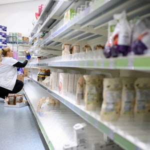 Eine Mitarbeiterin räumt in einem Drogeriemarkt Produkte in ein Regal.
