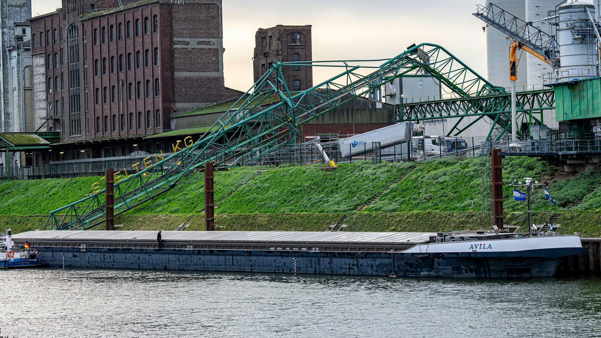 Ein Kran liegt zusammengebrochen am Ufer im Krefelder Hafen.