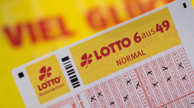 Ein Lottoschein mit der Aufschrift «Lotto 6 aus 49» ist vor einem Schriftzug «Viel Glück» zu sehen.