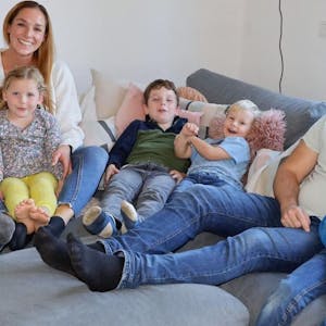Porträt einer Großfamilie: Eltern und fünf Kinder auf einem Sofa