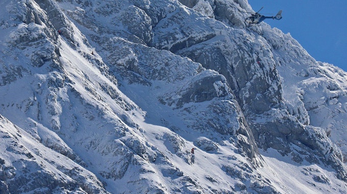 Bergretter suchen am Hochkalter bei Ramsau bei Berchtesgaden bei Schnee unter schwierigen Bedingungen nach einem Bergsteiger.
