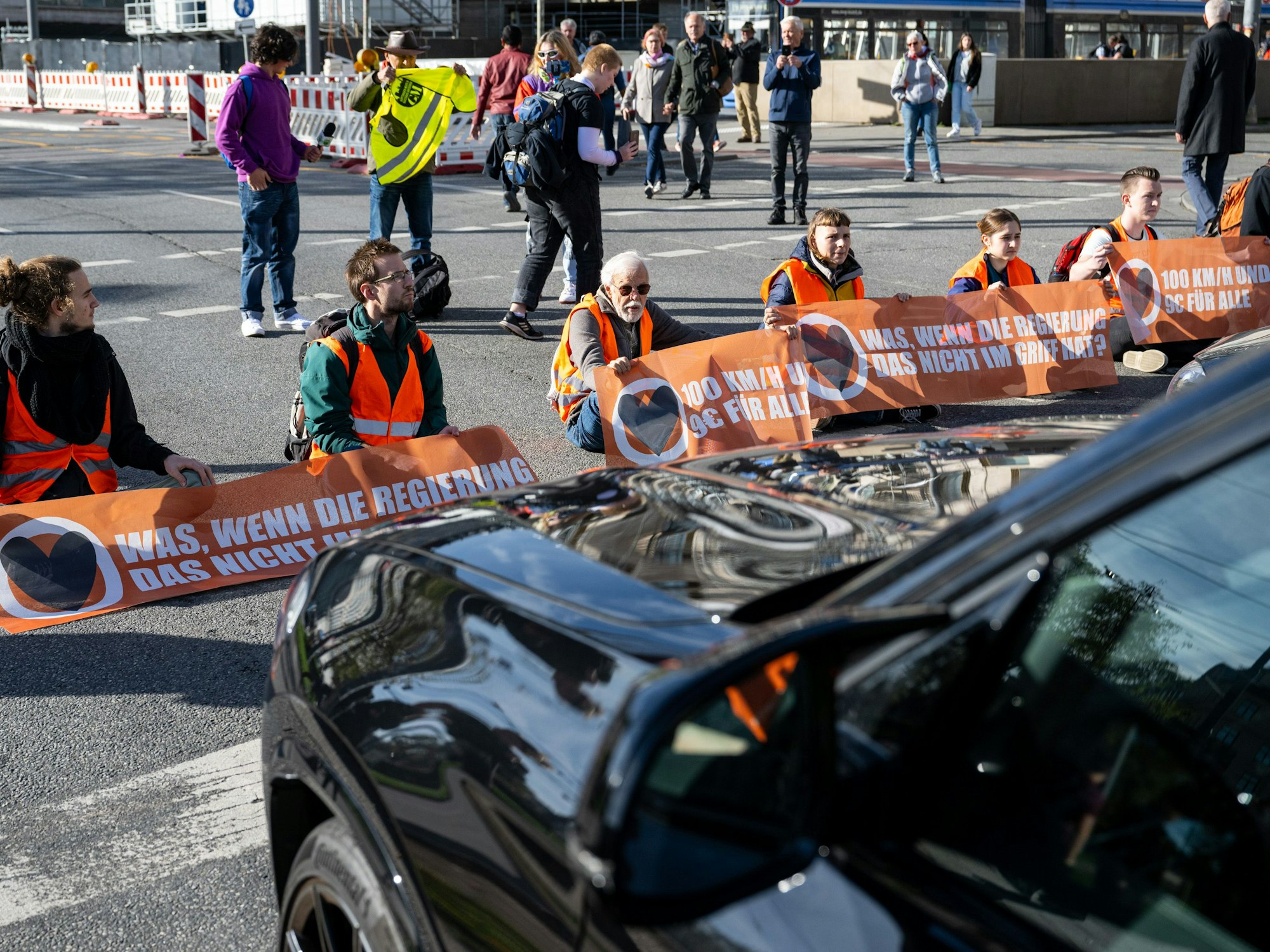 Klimaaktivisten haben sich am Karlsplatz in der Münchner Innenstadt auf die Fahrbahn geklebt und blockieren die Straße.