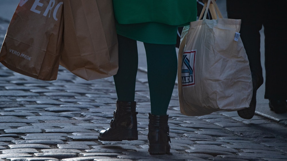 Der Discounter Aldi Süd stimmt Verbraucher auf noch schwierigere Zeiten ein. Unser Archivbild (2021) zeigt eine Frau mit mehreren Einkaufstüten in einer Fußgängerzone in Stralsund.