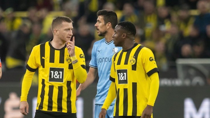 Dortmunds Marco Reus (l) spricht nach seiner Einwechslung mit Teamkollege Youssoufa Moukoko.